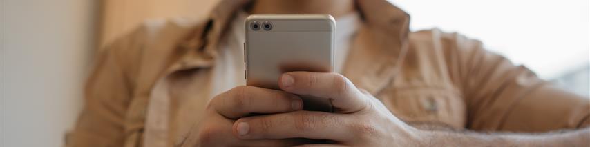 Gentleman using his silver mobile phone smiling